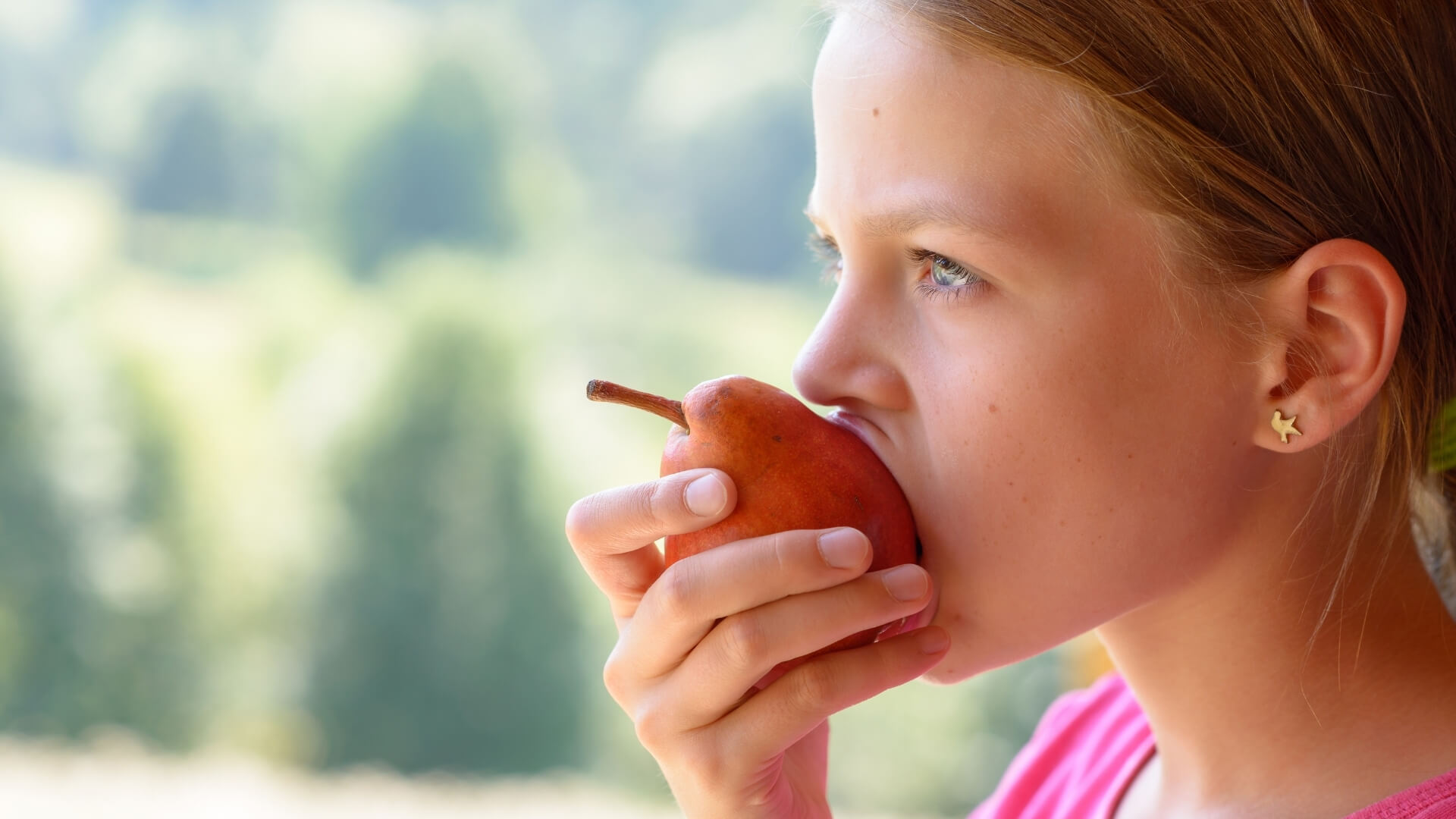 bambina che mangia una pera nel momento giusto della giornata