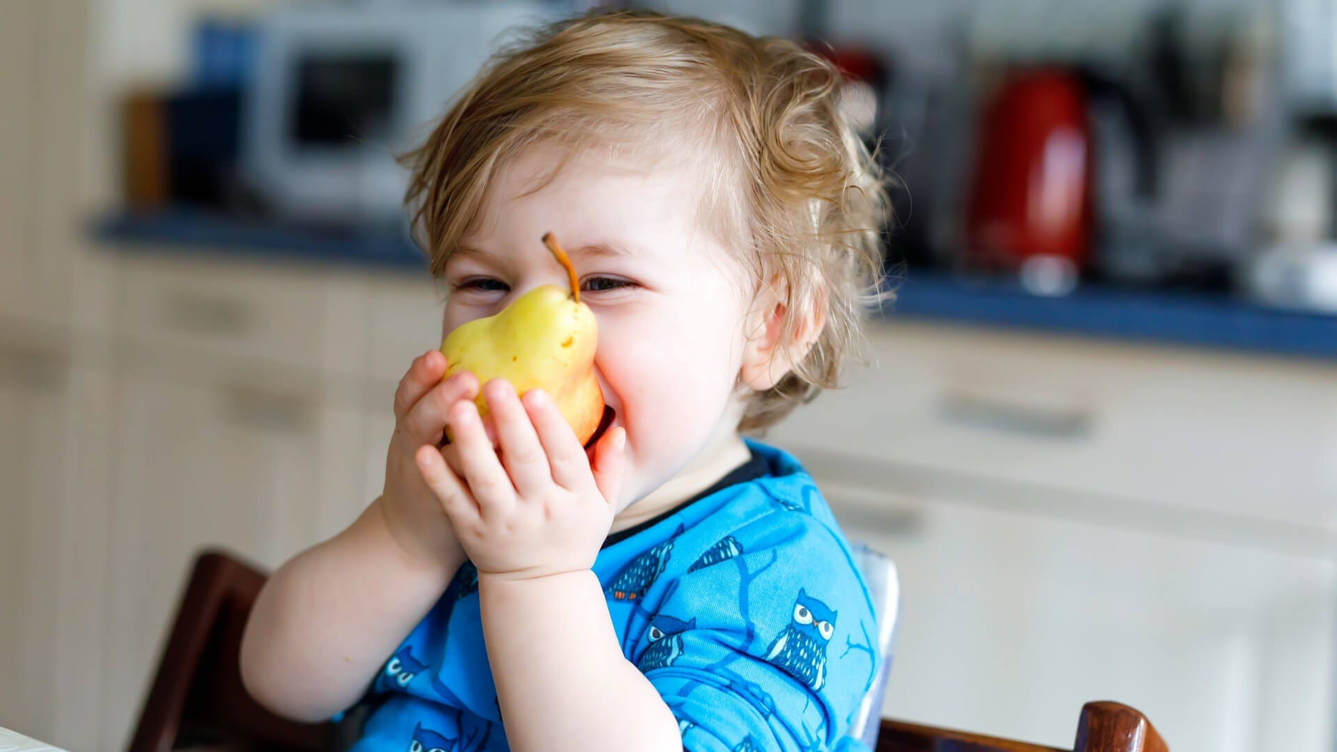 bambino che mangia una pera assaporandone il gusto